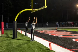 Two referees with hands in the air