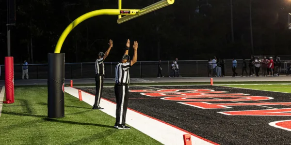 Two referees with hands in the air